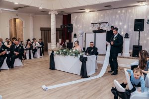 Best man delivering a speech with a long unrolling scroll at the wedding reception