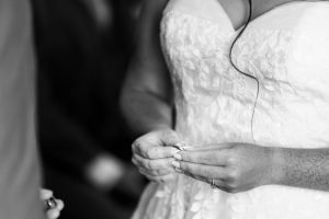 Black and white close-up of the bride holding the wedding rings before the exchange